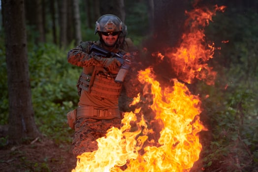 Soldier in Action at Night jumping over fire photo