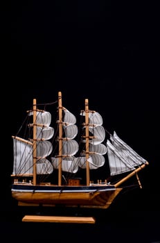 Wooden sailboat on black photo