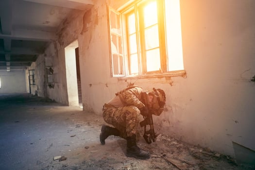soldier in action near window changing magazine and take cover photo