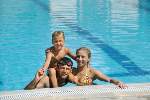 happy young family have fun on swimming pool photo