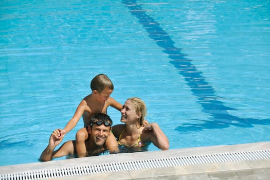 happy young family have fun on swimming pool photo