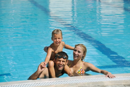 happy young family have fun on swimming pool photo