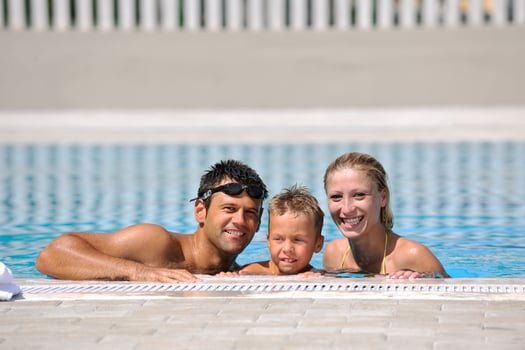 happy young family have fun on swimming pool photo