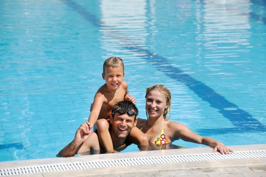 happy young family have fun on swimming pool photo