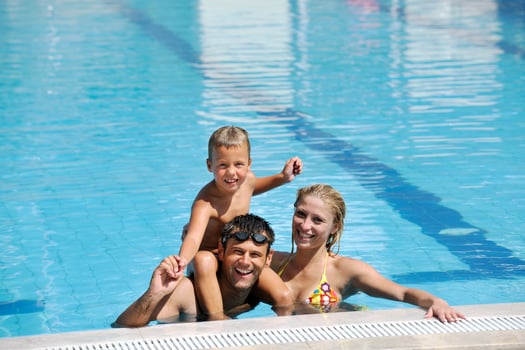 happy young family have fun on swimming pool photo
