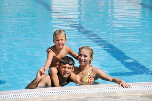 happy young family have fun on swimming pool photo