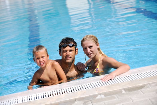 happy young family have fun on swimming pool photo