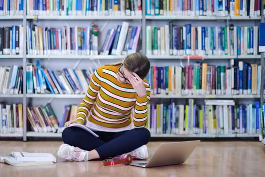 the student uses a notebook and a school library photo