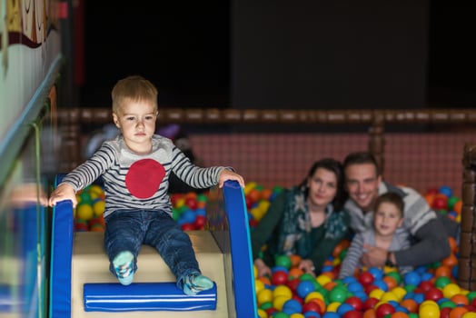 parents and kids playing in the pool with colorful balls photo