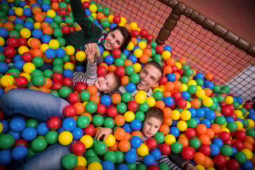 parents and kids playing in the pool with colorful balls photo