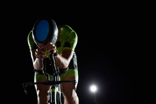 triathlon athlete riding bike fast  at night photo