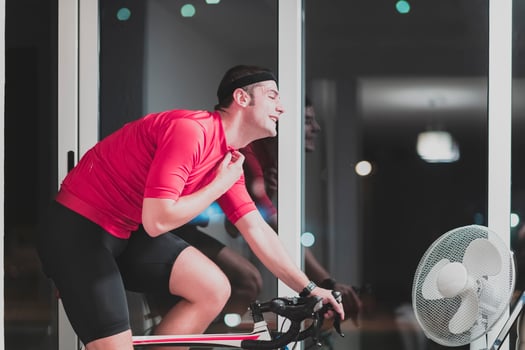 Man cycling on the machine trainer he is exercising in the home at night playing online bike racing game photo
