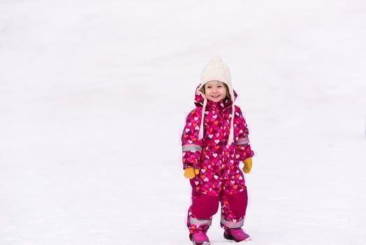 little girl having fun at snowy winter day photo