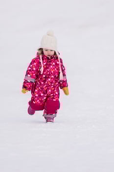 little girl having fun at snowy winter day photo