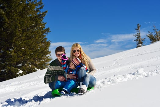 family having fun on fresh snow at winter photo