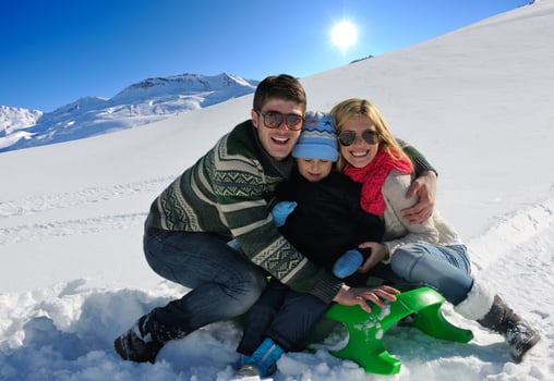family having fun on fresh snow at winter vacation photo