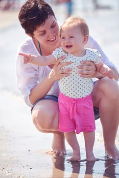 mom and baby on beach  have fun photo