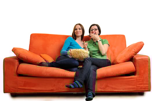 female friends eating popcorn and watching tv at home photo