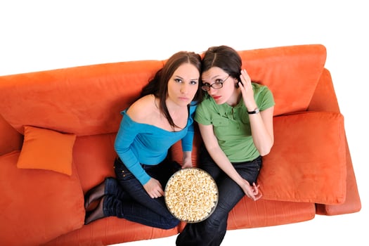 female friends eating popcorn and watching tv at home photo
