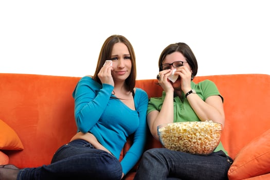 female friends eating popcorn and watching tv at home photo