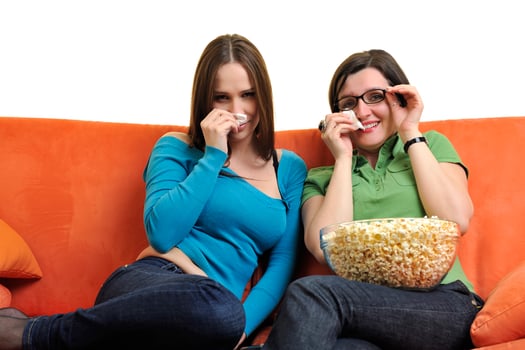 female friends eating popcorn and watching tv at home photo