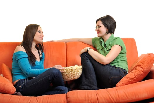 female friends eating popcorn and watching tv at home photo