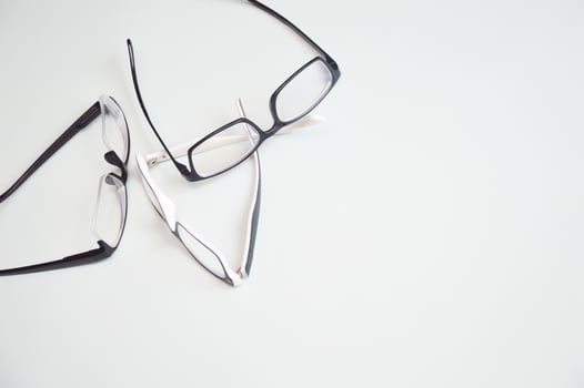 Many eyeglasses for vision correction lying isolated on white background. Optics, eye examination, ophthalmology. photo