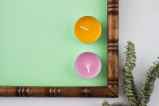 Part of wooden carved frame with a green background decorated with candles and branch. photo