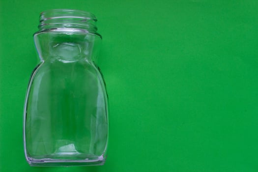 Transparent glass empty bottle on a green background with place for your design. photo