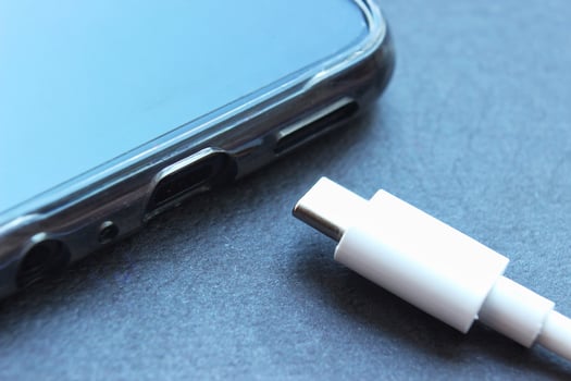 Close-up of a USB type-c connector of a smartphone and a charging cable. Fast charging. Black discharged phone on black background photo