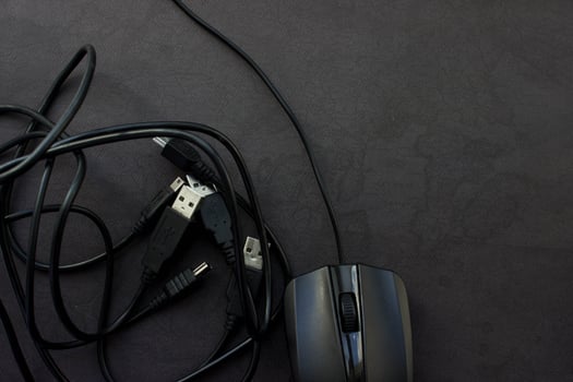 Black computer mouse with USB and mini USB cables on black background with place for your design. photo