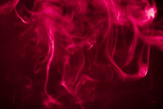 Red smoke in a dark room in a black background photo