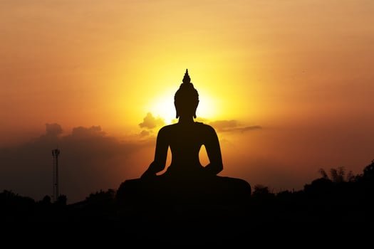 silhouette of buddha at sunset photo
