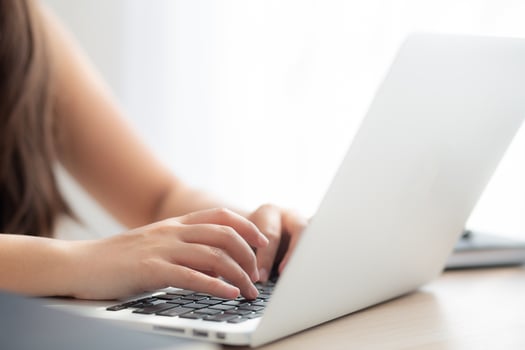 Closeup freelance asian woman working and typing on laptop computer at desk office with professional, girl using notebook checking email or social network, business and lifestyle concept. photo