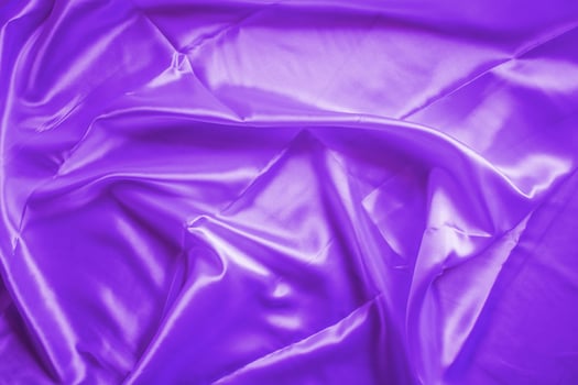 The wrinkled surface of the proton purple cloth. The purple shiny cloth. photo