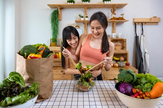 Asian couple of same sex marriage cooking healthy salad together in kitchen during pride month to promote equality and differences of homosexual and discrimination concept photo