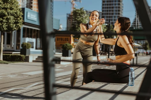 Young women in sportswear exercising on a river promenade photo