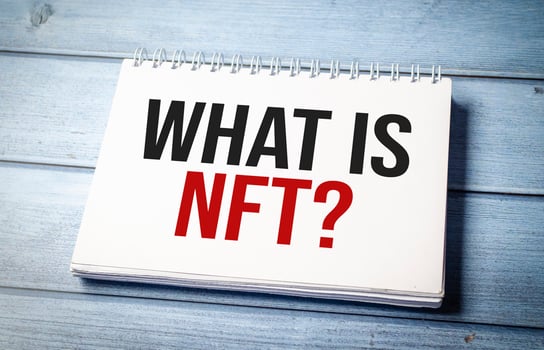 Paper with WHAT IS NFT on wooden desk photo