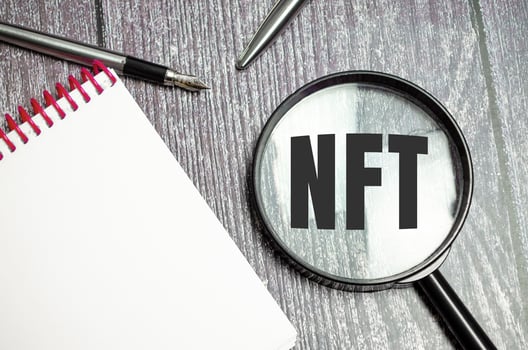 Paper with NFT a table on magnifying glass, business concept photo
