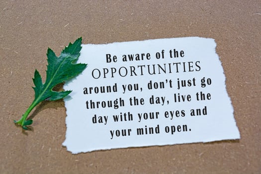 Motivational and inspirational quote on white paper with flowers on wooden desk. photo