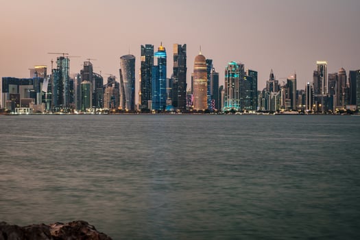 Doha Qatar skyline at night showing skyscrapers lights reflected in the Arabic gulf photo