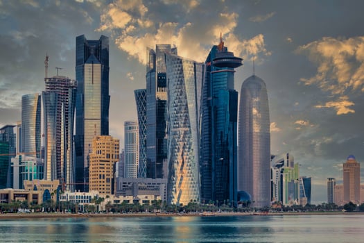 Doha Qatar skyline sunset view showing financial district in West Bay with modern skyscrapers , cars, trees and clouds in the sky. photo