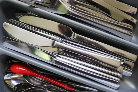 Selective focus of shiny cutlery in a dishwasher after cleaning. Forks, Knifes and Spoons photo