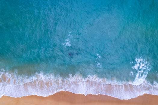 Aerial view sandy beach and waves Beautiful tropical sea in the morning summer season image by Aerial view drone shot, high angle view Top down sea waves photo