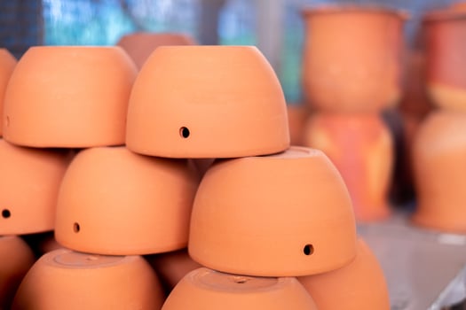 Stacks of orange various terracotta pots for plants for sale at a garden store. photo