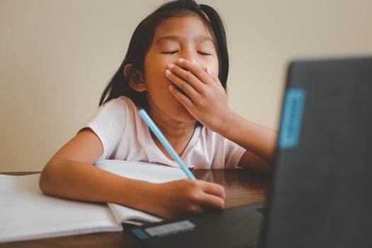 Thai girl in online learning class at home during the COVID-19 situation. Student learning form notebook during quarantine. Felling boring. Selected focus. Online education, home school concept. photo