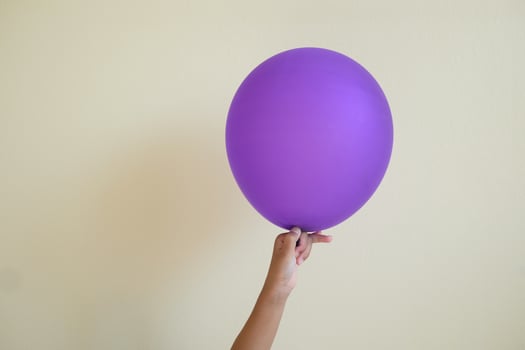 close up hand's kid holding the pink balloon isolated on white background. photo