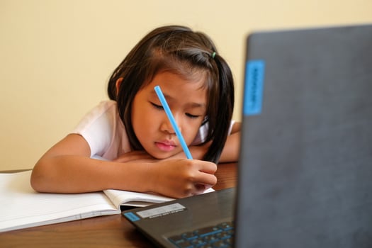 Thai girl in online learning class at home during the COVID-19 situation. Student learning form notebook during quarantine. Felling boring. Selected focus. Online education, home school concept. photo