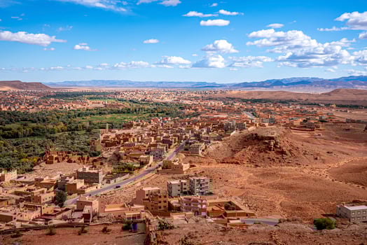 Scenic landscape of buildings in town with mountains backdrop photo