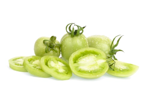 Fresh green tomatoes, whole and sliced, have a surface water spray on white background. photo